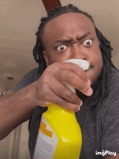 Man With Dreadlocks Spraying Yellow Bottle Of Cleaner GIF