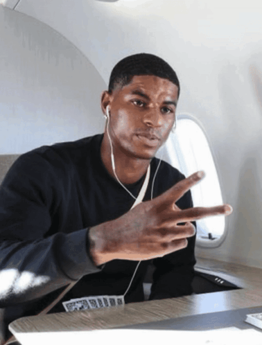Man With Ear Buds Giving Peace Sign On Airplane GIF