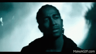 Man With Ear Piercing Looking At Camera In Dark Room GIF