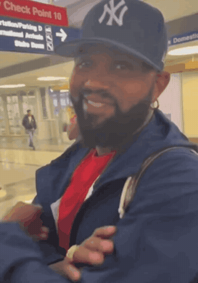Man With Earbuds Smiling Beside Blue Stuffed Animal GIF