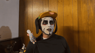 Man With Face Paint And Yellow Hat Holding Stuffed Mouse GIF