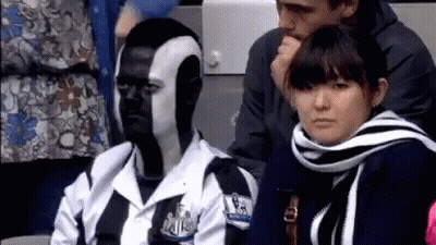 Man With Face Paint Sitting Next To Woman In Scarf GIF