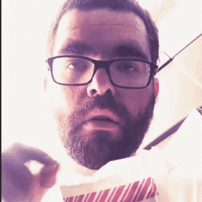 Man With Glasses And Beard Holding Paper GIF