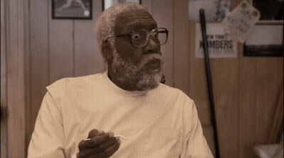 Man With Glasses And Beard Holding Spoon In Front Of Numbers Sign GIF