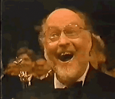 Man With Glasses And Beard Laughing Before Crowd GIF