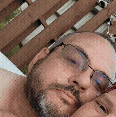 Man With Glasses And Beard Laying On Another Man's Chest GIF