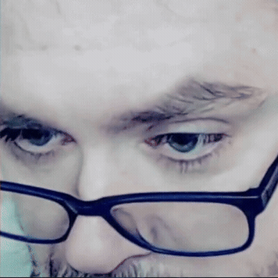 Man With Glasses And Beard Looking At Camera GIF