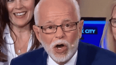 Man With Glasses And Beard Making Funny Face Behind Two Women Smiling GIF