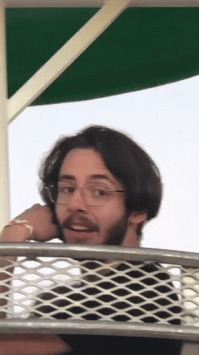 Man With Glasses And Beard Over Wire Fence GIF