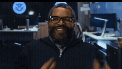 Man With Glasses And Beard Smiling Before U.S. Department Of Homeland Security Sign GIF