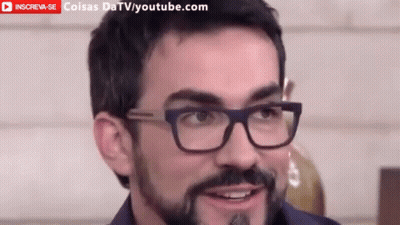 Man With Glasses and Beard Smiling in Front of YouTube Banner