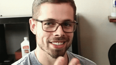 Man With Glasses And Beard Smiling Near Cleaner Bottle GIF