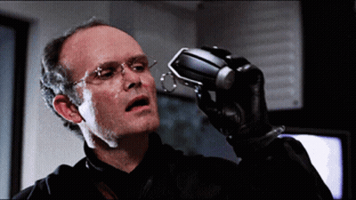 Man With Glasses And Black Glove Holding Small Object GIF
