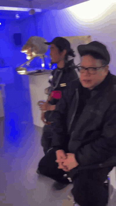 Man With Glasses and Black Hat Kneeling