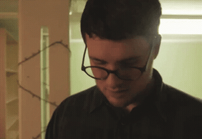 Man With Glasses And Black Shirt Looking Down GIF