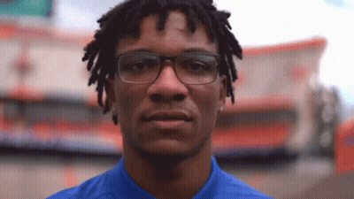 Man With Glasses And Dreadlocks Looking At Camera GIF
