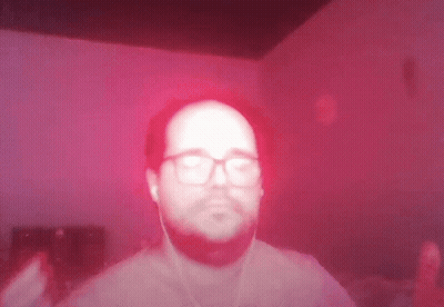 Man With Glasses And Ear Buds On Red Background GIF