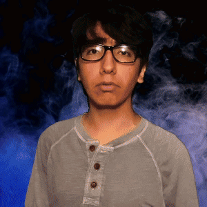 Man With Glasses And Gray Shirt In Front Of Blue Background GIF