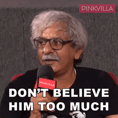 Man With Glasses And Mustache Holding Microphone Says Don't Believe Him Too Much GIF