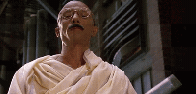 Man With Glasses And Mustache In White Robe Holding Stick GIF