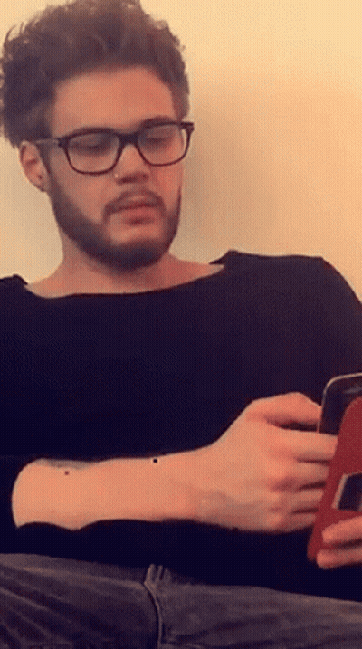 Man With Glasses And Nose Ring Looking At Phone GIF
