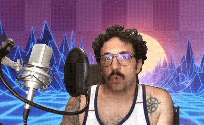 Man With Glasses And Tattoo Singing Into Microphone GIF