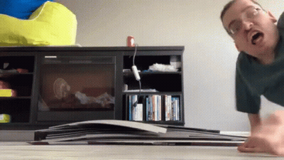 Man With Glasses Doing Push Ups In Front Of Bookshelf GIF