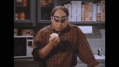 Man With Glasses Eating Bread In Kitchen GIF