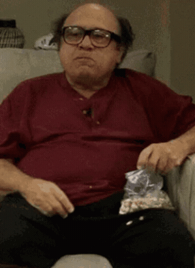 Man With Glasses Eating Popcorn On Couch GIF