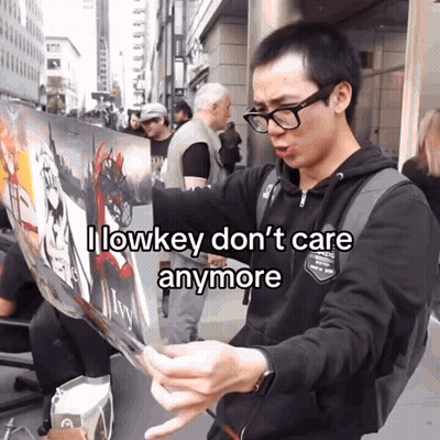Man With Glasses Holding Sign Saying I Lowkey Don't Care Anymore GIF