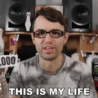Man With Glasses Holding Water Bottle And Sign Saying This Is My Life GIF