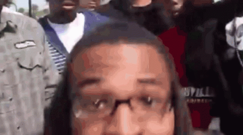 Man With Glasses In Crowd Looking At Camera GIF