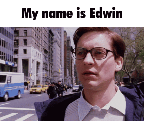 Man With Glasses In Front Of City Street Saying My Name Is Edwin GIF