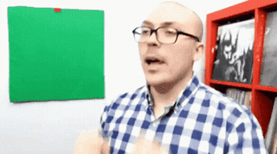 Man With Glasses In Plaid Shirt In Front Of Green Board GIF