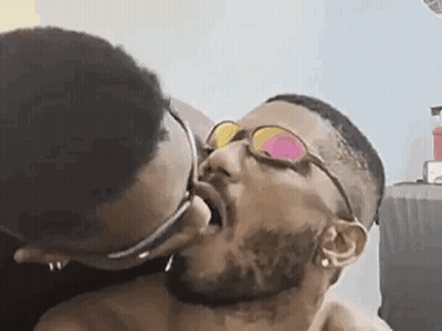 Man With Glasses Kissing Another Man On Cheek GIF