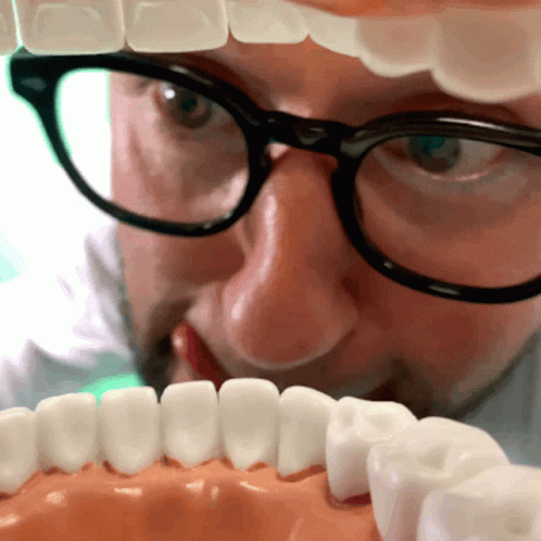 Man With Glasses Looking At Teeth Model GIF