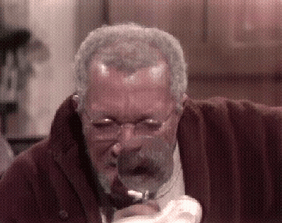 Man With Glasses Looking Through Magnifying Glass GIF