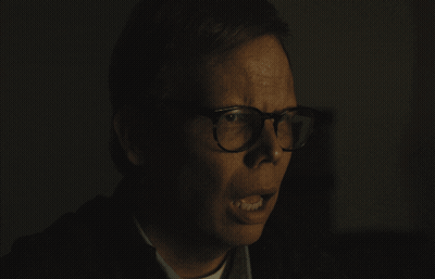 Man With Glasses Making Funny Face In Dark Room GIF