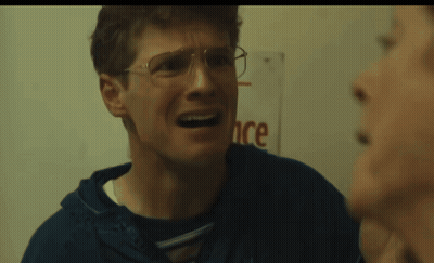 Man With Glasses Making Funny Face In Front Of Ance Sign GIF