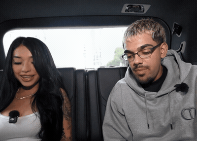 Man With Glasses Next To Woman In White Tank Top GIF
