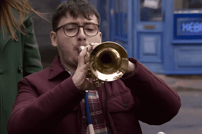 Man With Glasses Playing Trumpet At Blue Door Picker GIF
