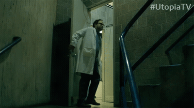 Man With Glasses Saying Wait In Front Of Utopia TV Logo GIF