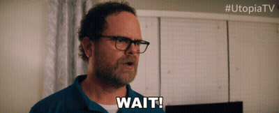 Man With Glasses Saying Wait In Front Of Utopiatv Logo GIF