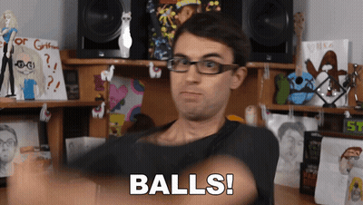 Man With Glasses Says Balls In Front Of Stuffed Animals Desk GIF