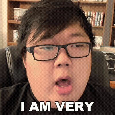 Man With Glasses Says I Am Very in Front of Bookshelf