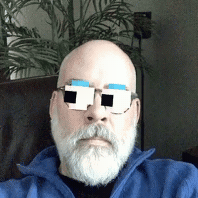 Man With Glasses Sitting At Table Touching Face GIF