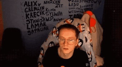 Man With Glasses Sitting In Front Of Graffiti Wall GIF