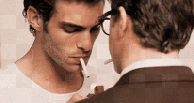 Man With Glasses Smoking Cigarette Next To Man In Suit GIF