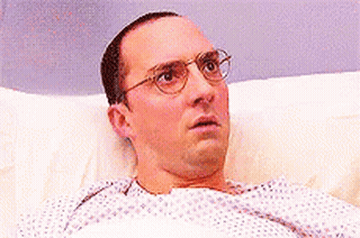 Man With Glasses Surprised In Hospital Bed GIF