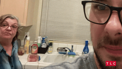 Man With Glasses Taking Selfie With Woman In Kitchen TLC GIF